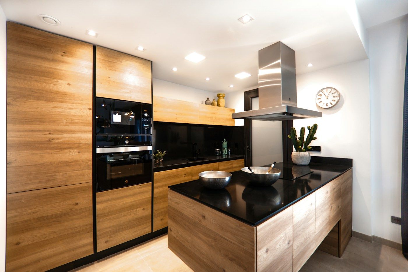 A modern kitchen with warm timber cabinets and a black island counter