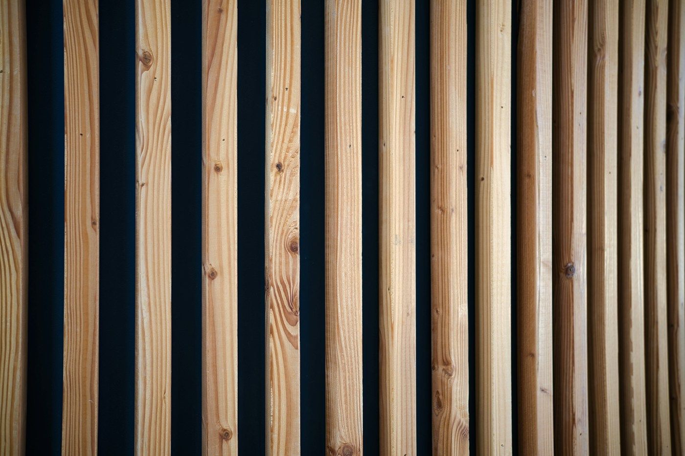 Close view of vertical timber slats against a dark backdrop